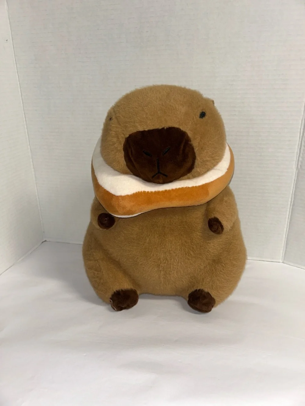 Plush Brown Capybara Pet Toy with Orange-and-White Donut Collar